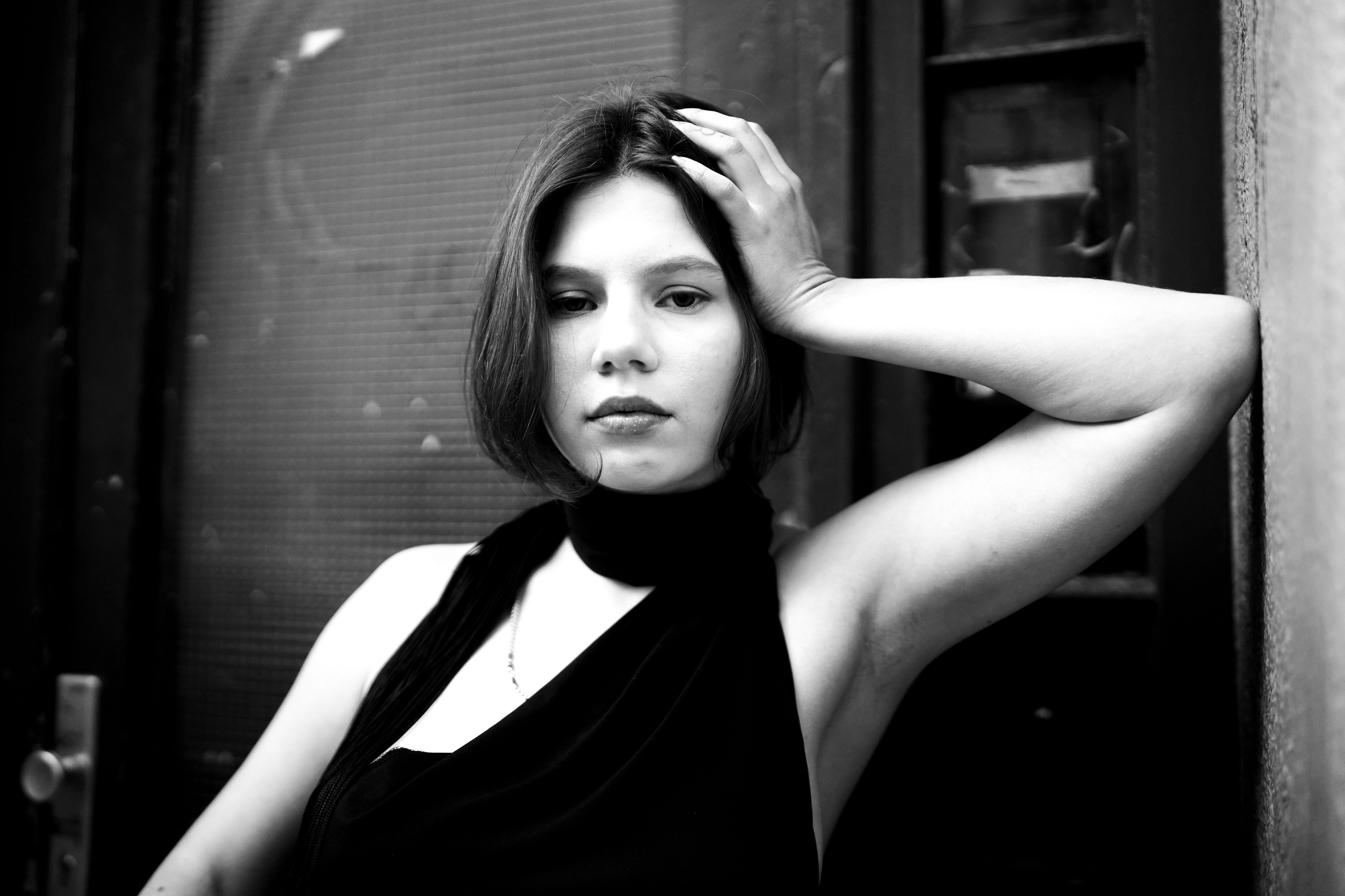 Elegant black and white portrait of a young woman posing thoughtfully.