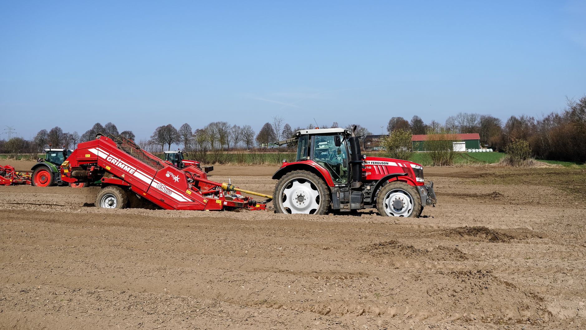 A tractor with farming equipment prepares field in spring, Geesthacht, Germany.