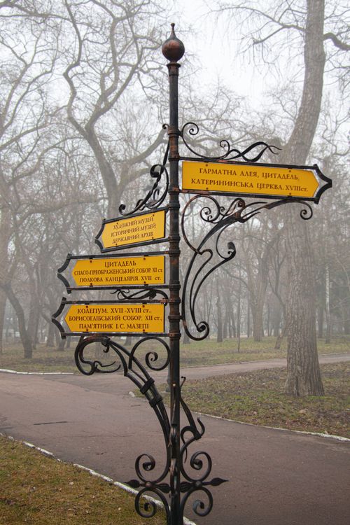 Free Intricate wrought iron signpost with directional signs in foggy Dytynets Park, Chernihiv, Ukraine. Stock Photo