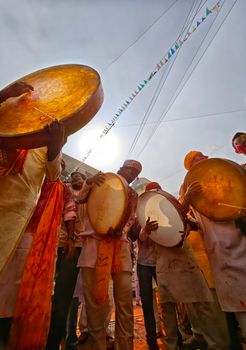Vibrant celebration with men playing traditional drums during a festival in Kolkata, India.