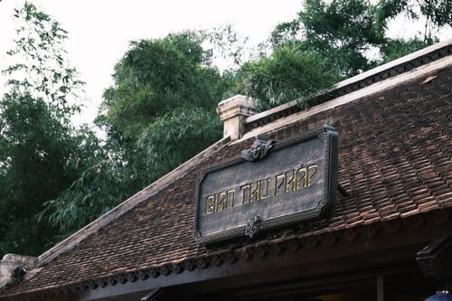 Free Close-up of a traditional Vietnamese building roof with intricate wooden signage. Stock Photo