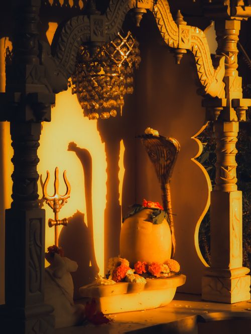 Free A beautifully carved stone sculpture illuminated by warm sunlight, showcasing Hindu symbols and intricate details. Stock Photo