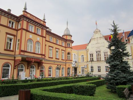 Charming view of historic buildings and gardens in Caransebeș, Romania.