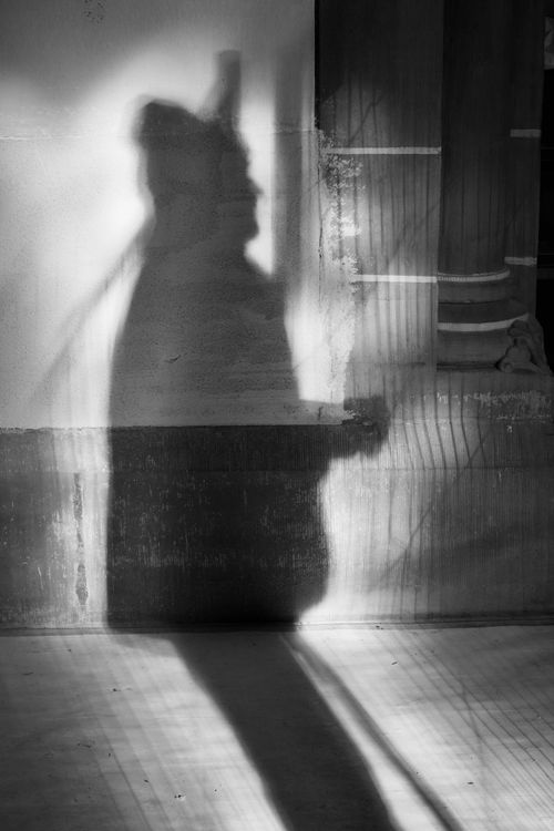 Free Black and white photo of a silhouette against a textured wall, evoking mystery and intrigue. Stock Photo