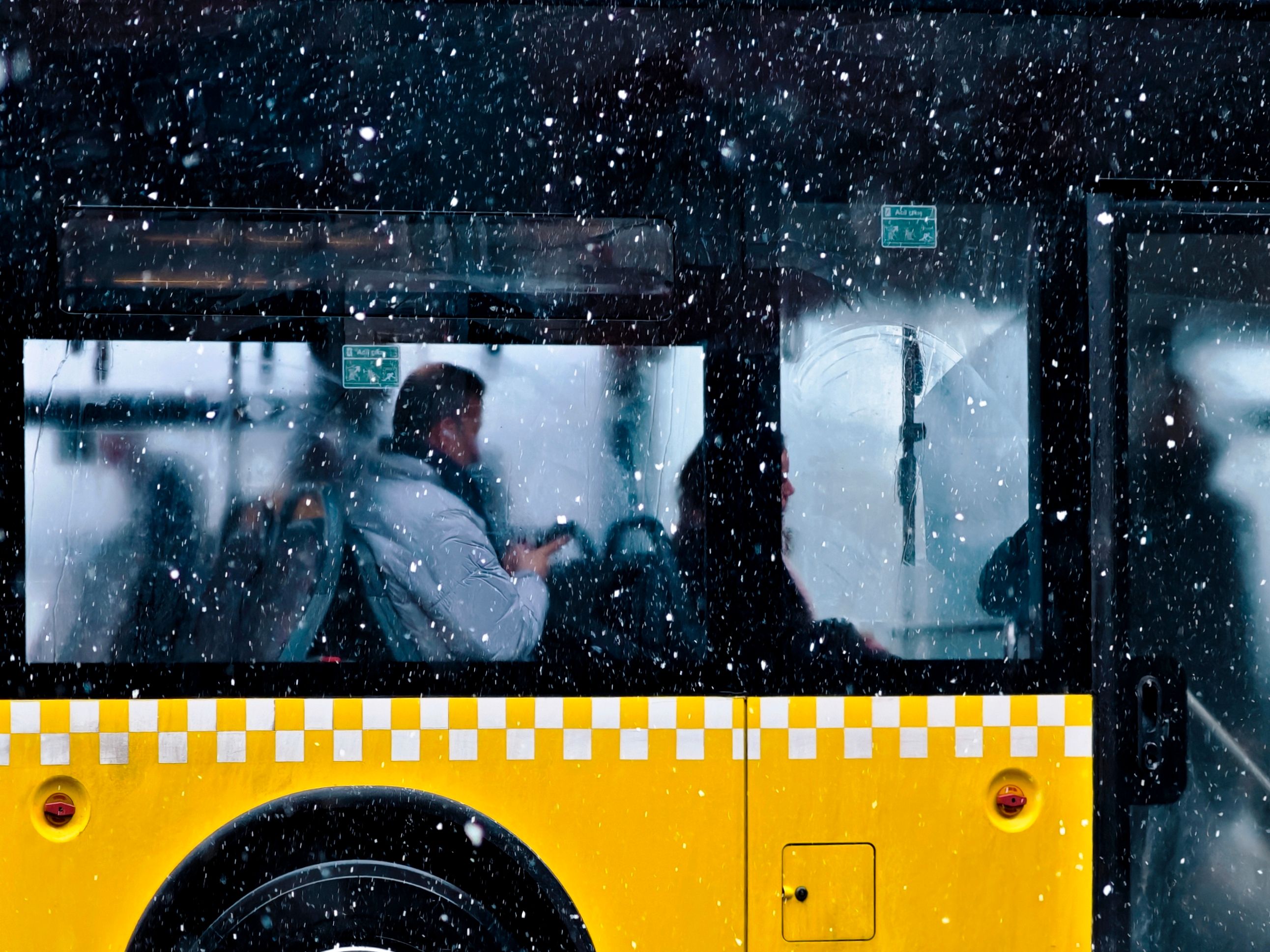 A yellow Strætó public bus driving through a street in Reykjavík, Iceland
