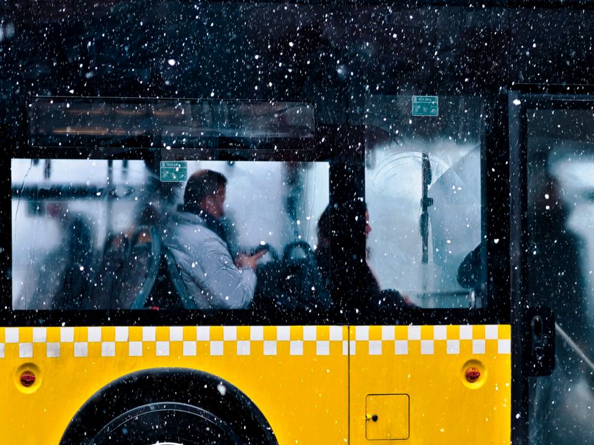 A yellow Strætó public bus driving through a street in Reykjavík, Iceland