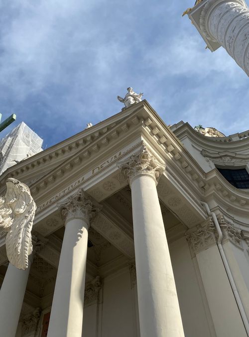 Free Low-angle view of the Karlskirche in Vienna, showcasing its stunning baroque architecture under a bright sky. Stock Photo