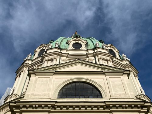 Free A stunning upward view of the St. Charles Church depicting its intricate Baroque architectural details against a blue sky. Stock Photo