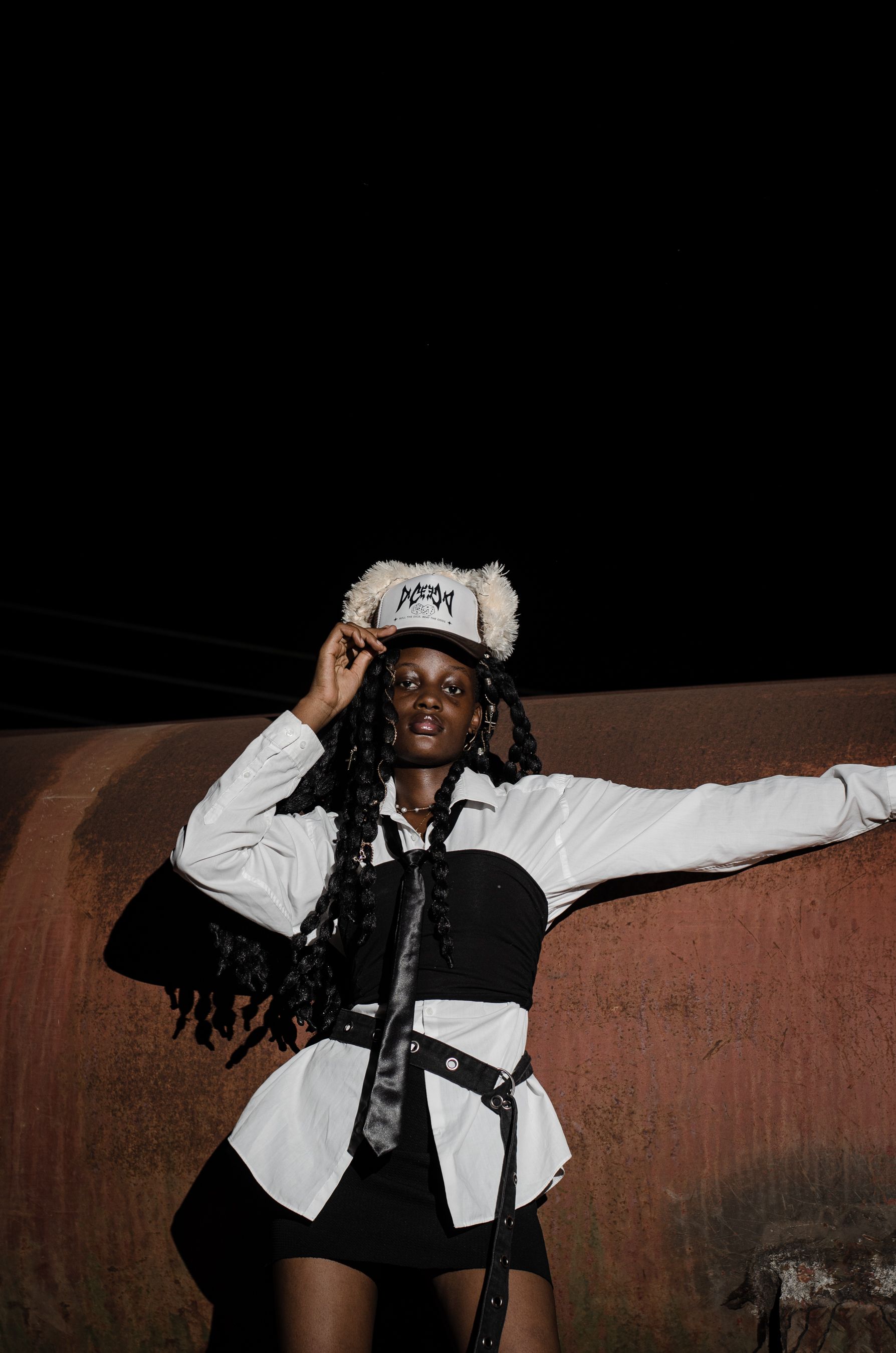 Stylish woman poses in urban setting at night, Nigeria. Fashion expression.