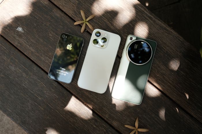 Three smartphones displayed side by side on a wooden surface