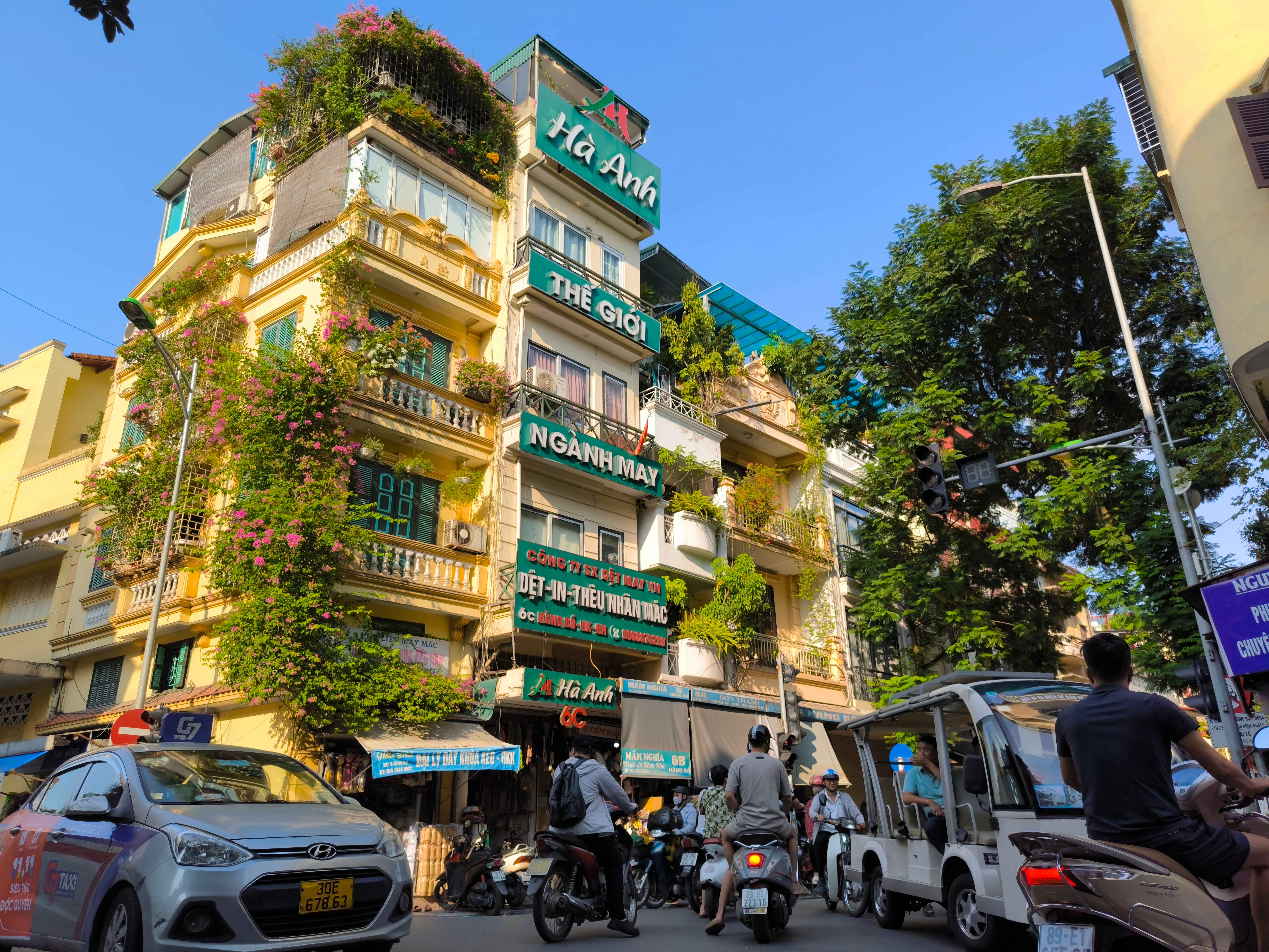 Vibrant street scene in Vietnam with colorful buildings and bustling traffic, capturing local architecture and urban life.