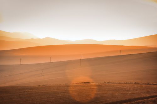 Free Beautiful sunset casting warm hues over the rolling hills of the Western Cape, South Africa. Stock Photo