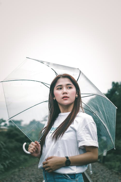 免費 拿著傘的白色長袖襯衫的女人 圖庫相片