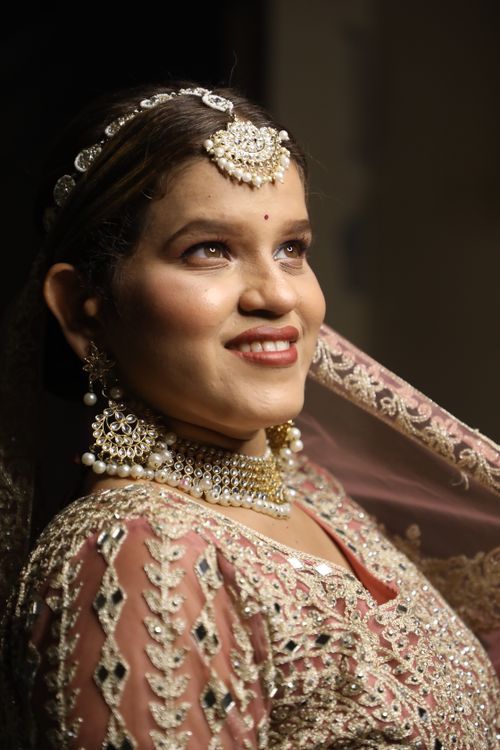 Free A beautiful bride adorned in intricate jewelry and traditional attire, exuding elegance and joy. Stock Photo