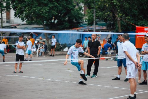 Free A competitive outdoor foot shuttlecock game with male participants enjoying a lively match. Stock Photo