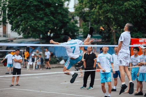 Free Capture of an intense Sepak Takraw match showing players mid-jump outdoors. Stock Photo