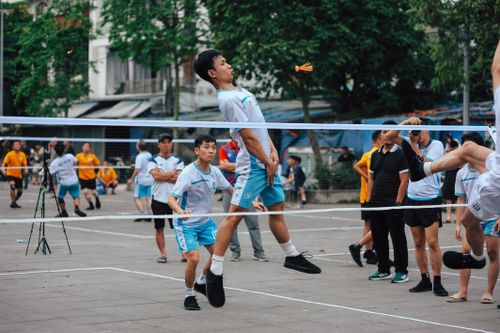 Free Energetic young men playing foot volleyball outdoors, showcasing teamwork and agility. Stock Photo
