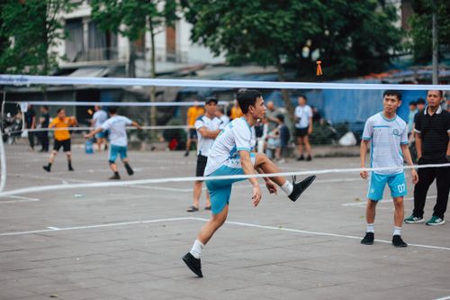 Free Dynamic scene of foot volleyball with young adults playing energetically outdoors. Stock Photo
