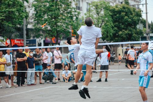 Free Exciting outdoor footvolley match with spectators cheering lively players. Stock Photo
