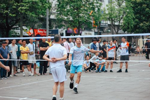 Free Energetic badminton game in urban setting with engaged spectators. Stock Photo
