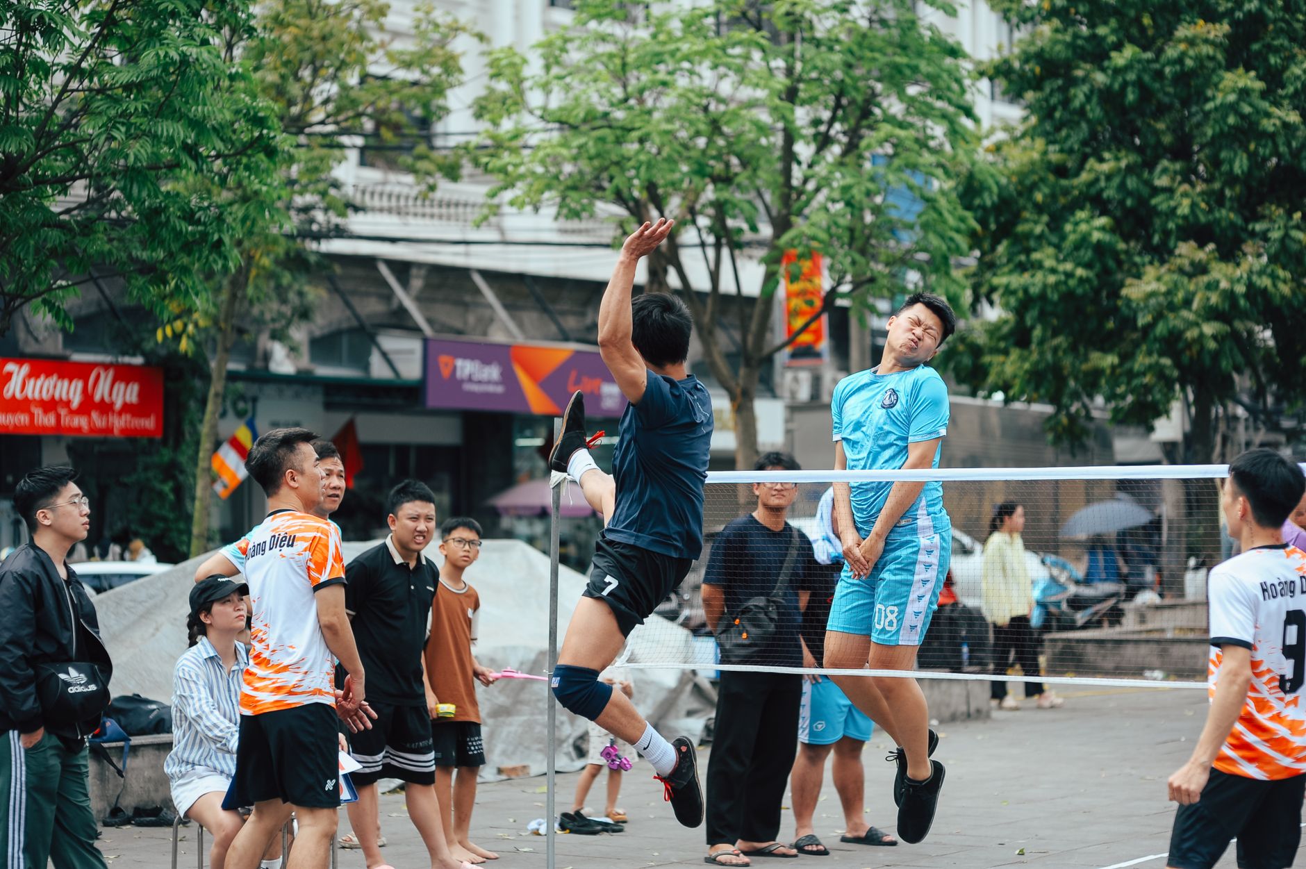Casual volleyball match in urban area with young adults competing outdoors.