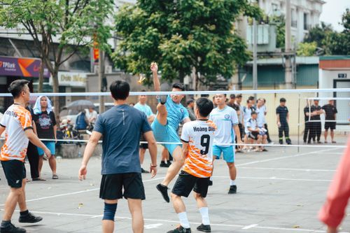 Free Players engaged in a lively outdoor volleyball match on a city street. Stock Photo