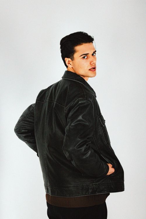 Free Portrait of a confident young man wearing a black leather jacket against a white background. Stock Photo
