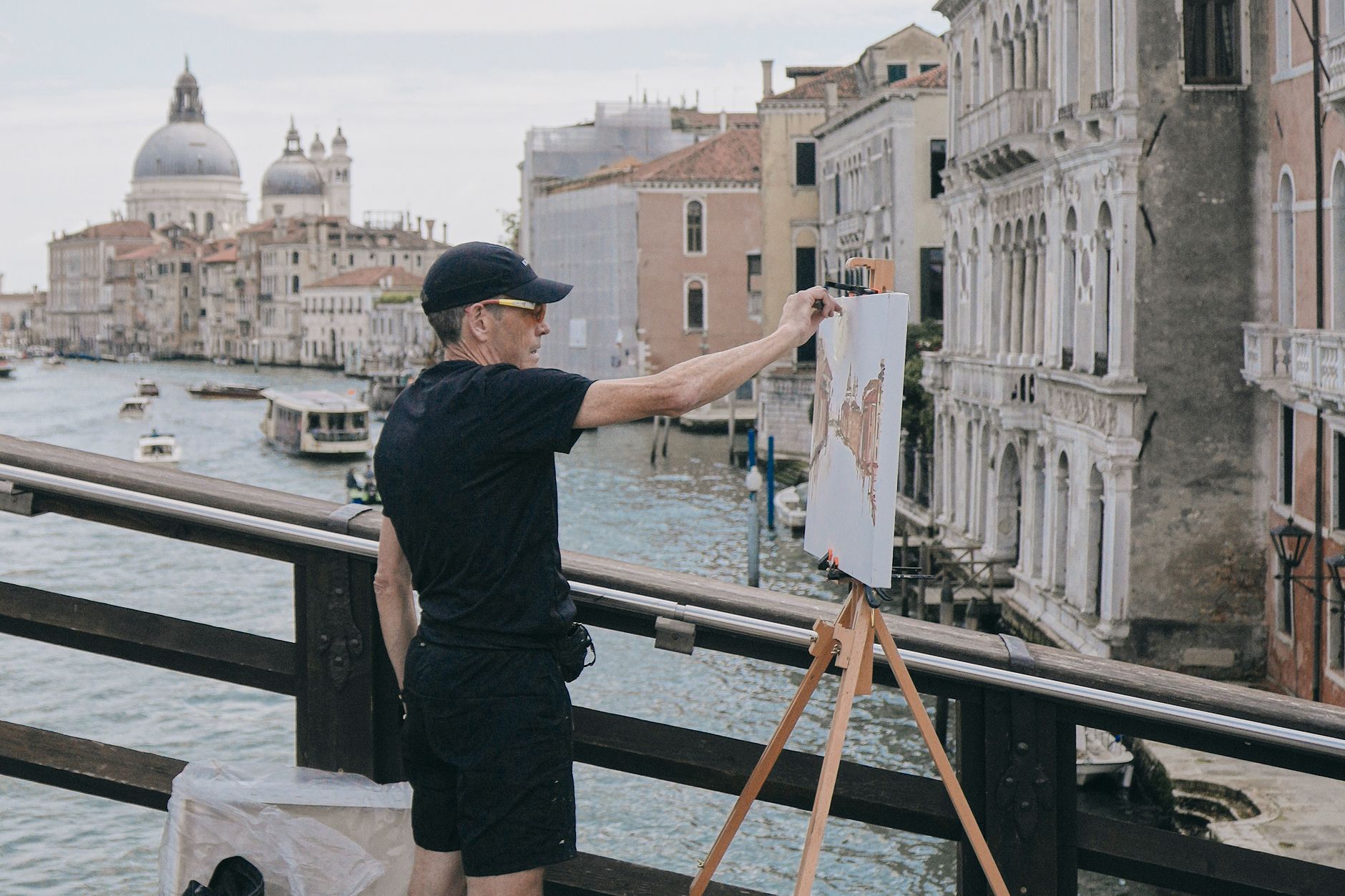 Artist painting a scenic Grand Canal view in Venice, Italy, capturing timeless architecture.