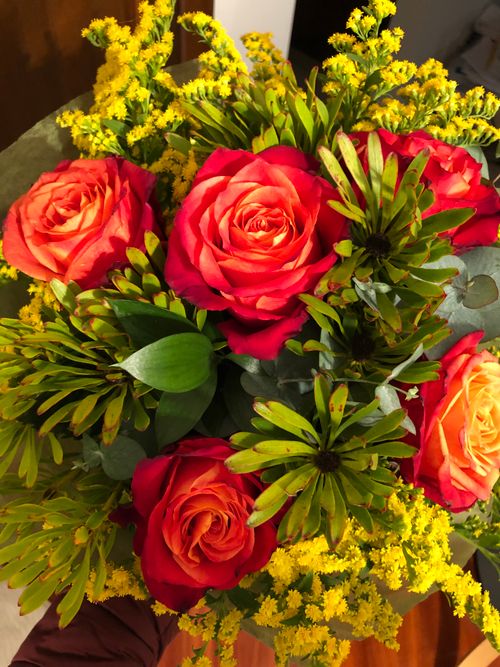 Free A colorful bouquet of red roses with yellow acacia flowers, showcasing vivid contrasts. Stock Photo