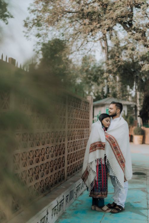 Free Indian couple wrapped in shawls in a serene outdoor setting, showcasing cultural attire. Stock Photo