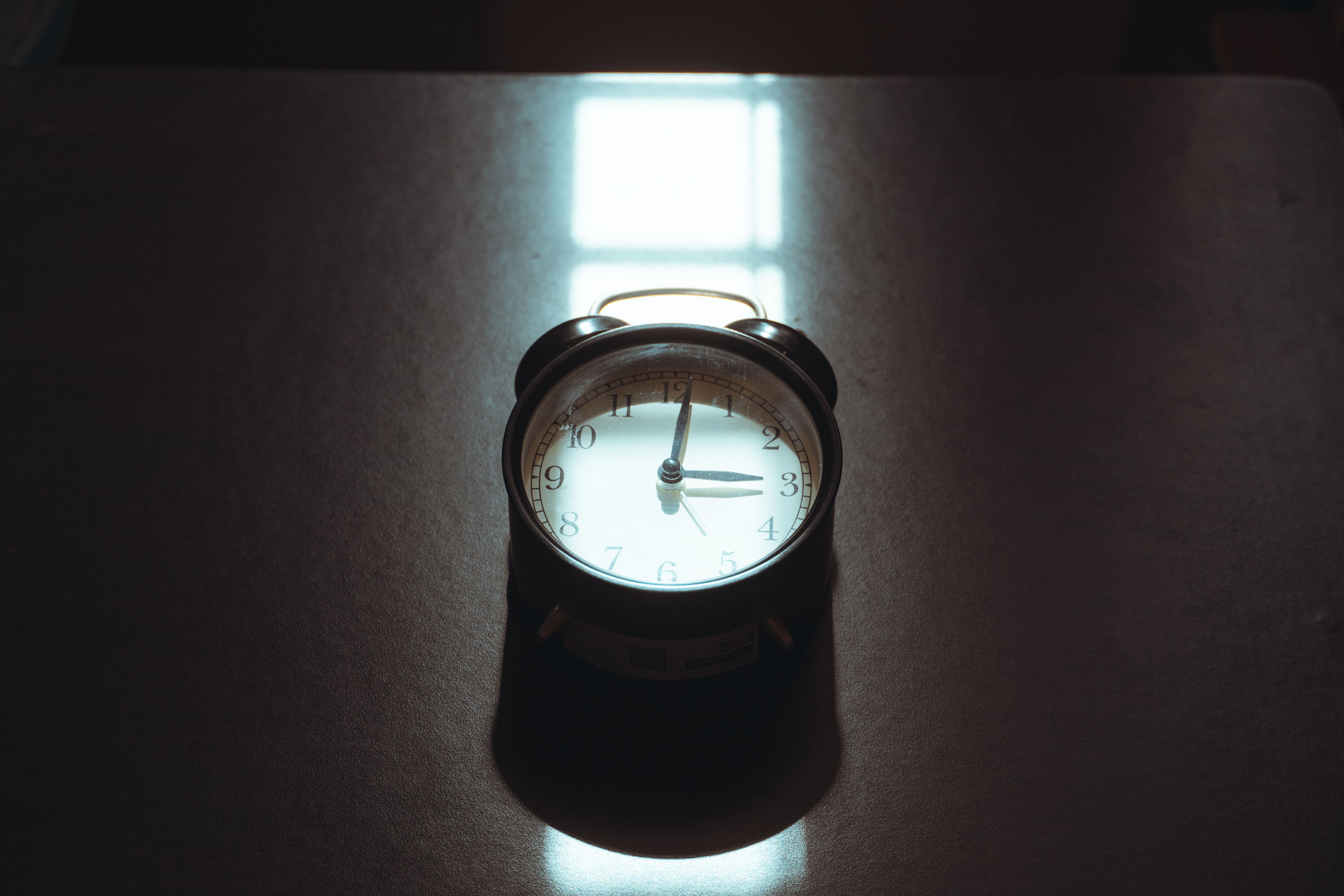 Vintage Alarm Clock with Artistic Shadows · Free Stock Photo