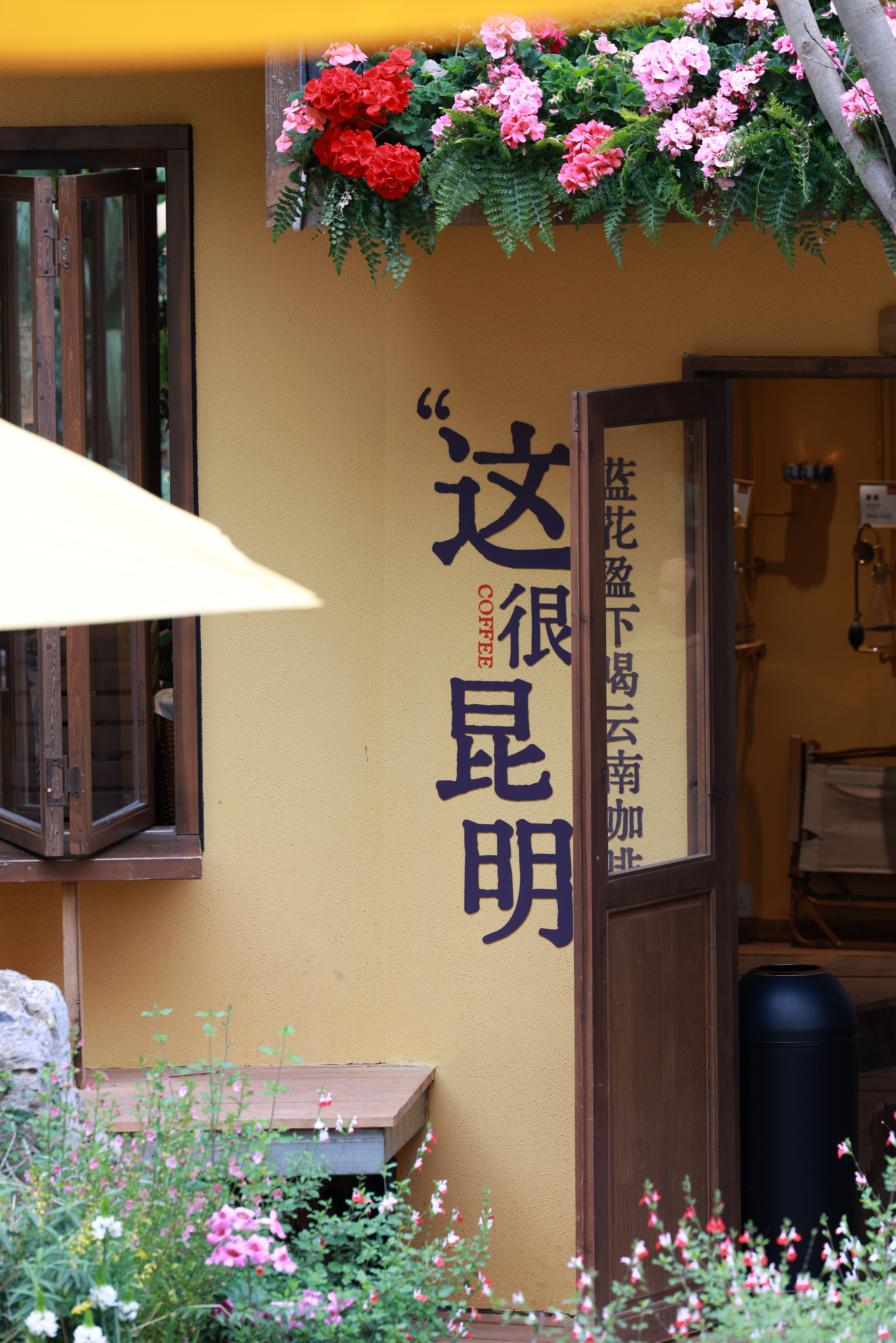 Cozy café entrance with vibrant flowers in Kunming, China.