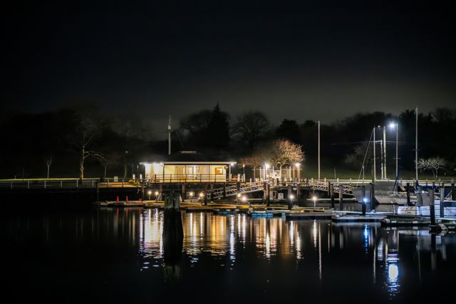 A dock at night with lights reflected on calm water — photo by Cara Denison on Pexels