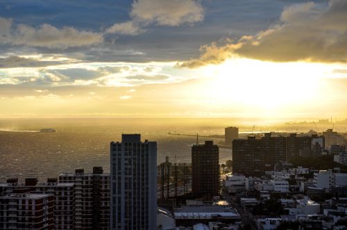 Free Captivating sunset over Montevideo skyline, highlighting city buildings and tranquil waters. Perfect for travel and urban themes. Stock Photo