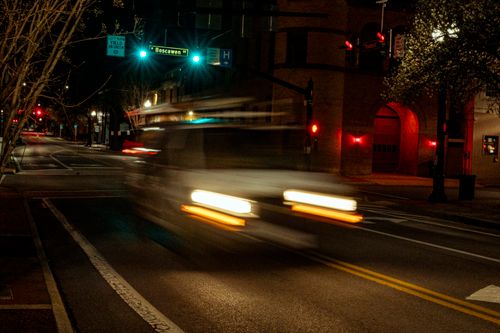 Free stock photo of blurred vehicle, car passing, city intersection Stock Photo