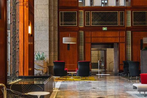 Free A stylish office atrium featuring contemporary interior design with comfortable seating and vibrant colors. Stock Photo