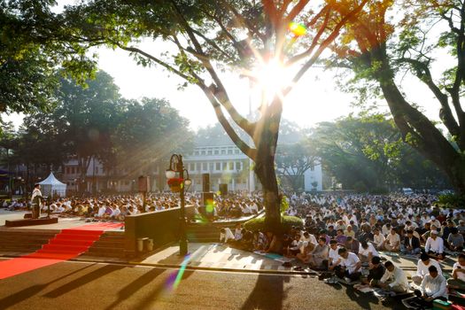 Sunlit outdoor prayer gathering under trees in Indonesia, reflecting unity and spirituality.