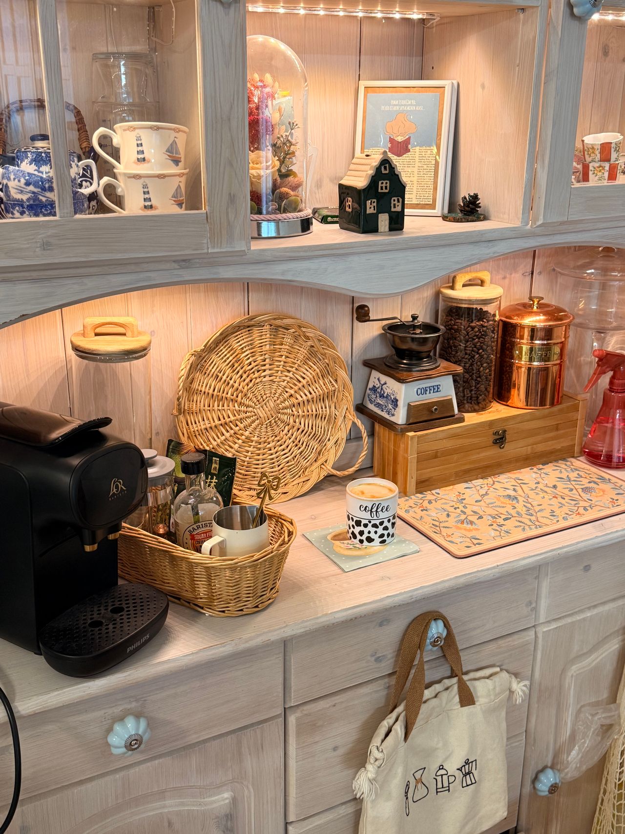 Cozy coffee station set up in a kitchen hutch with mugs and coffee accessories