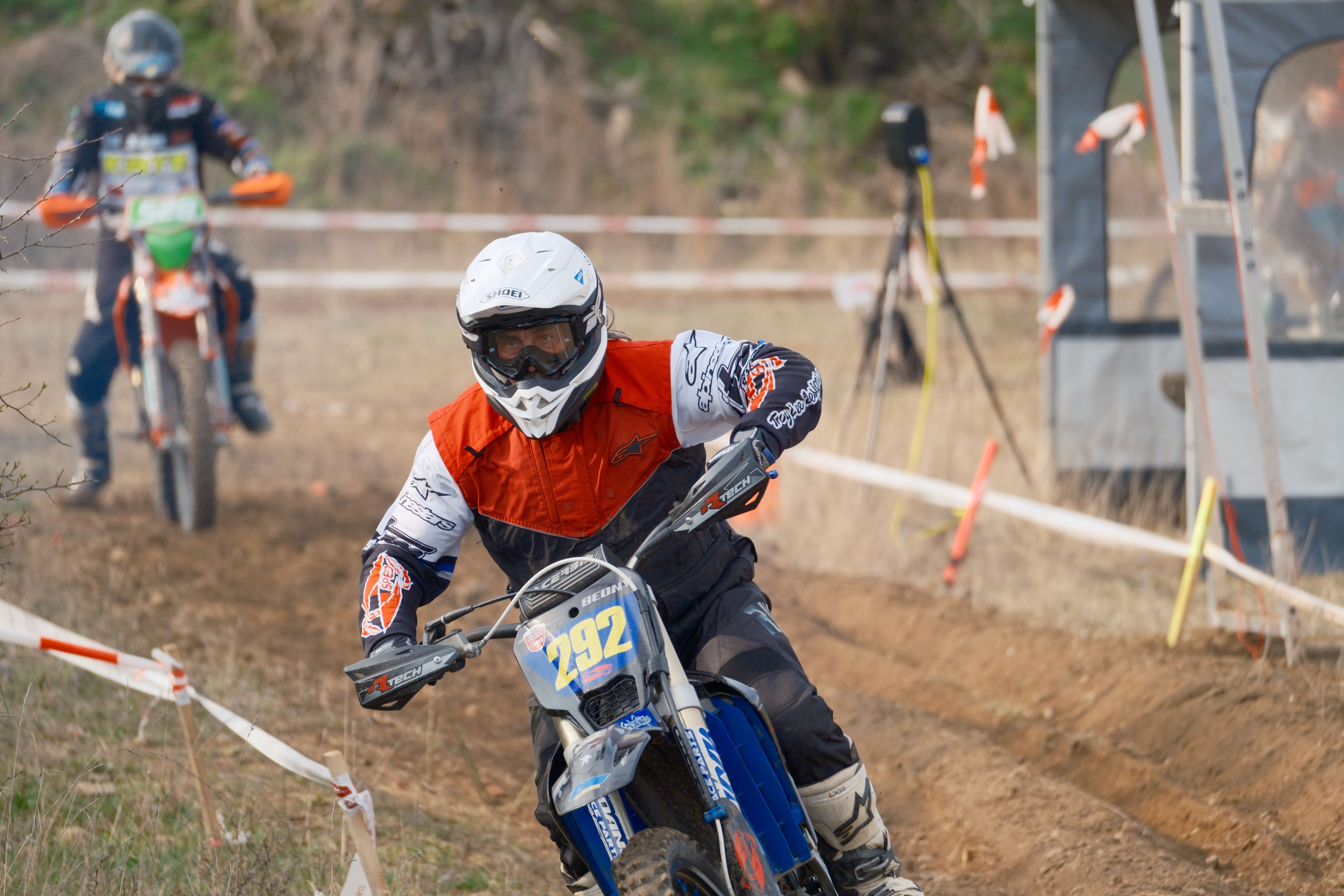 Two motocross riders race on a dirt track, showcasing high-speed action and competitive spirit.
