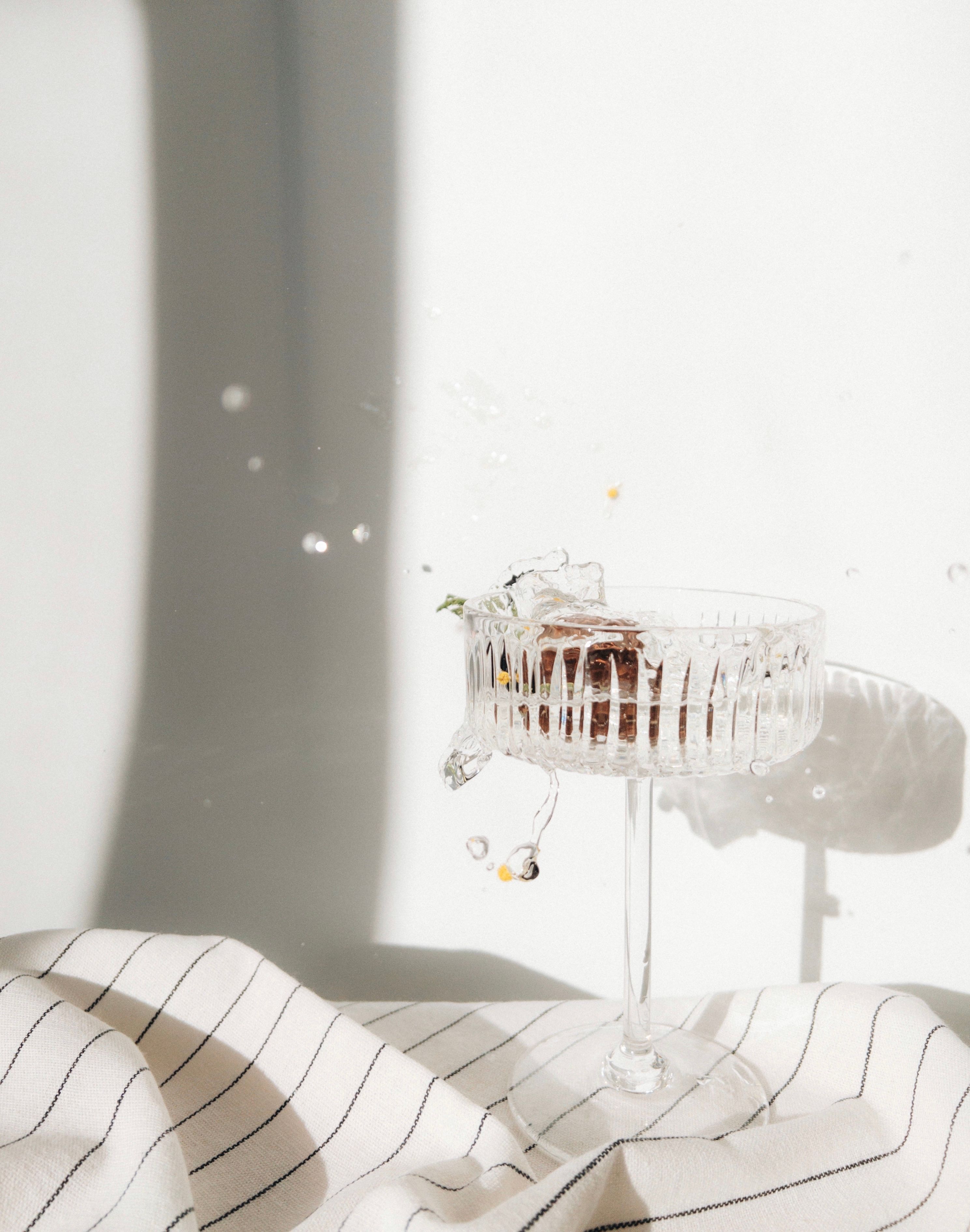 Elegant Glass with Splashing Liquid in Sunlight · Free Stock Photo