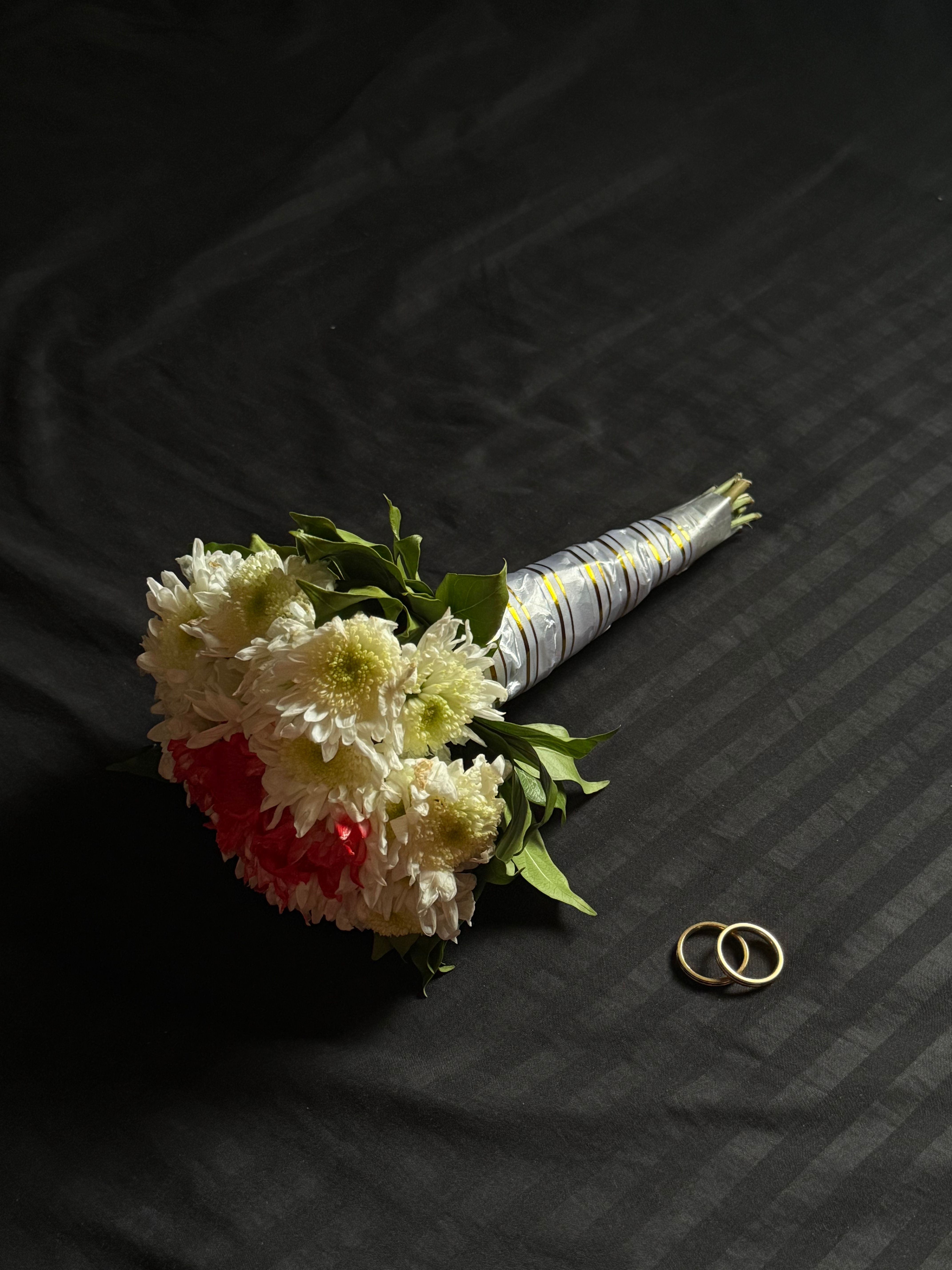A flower arrangement against a dark, textured tabletop.