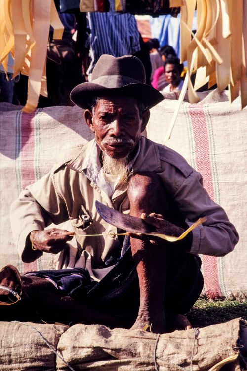 Free Elderly artisan working with bamboo at an outdoor market in Indonesia. Stock Photo