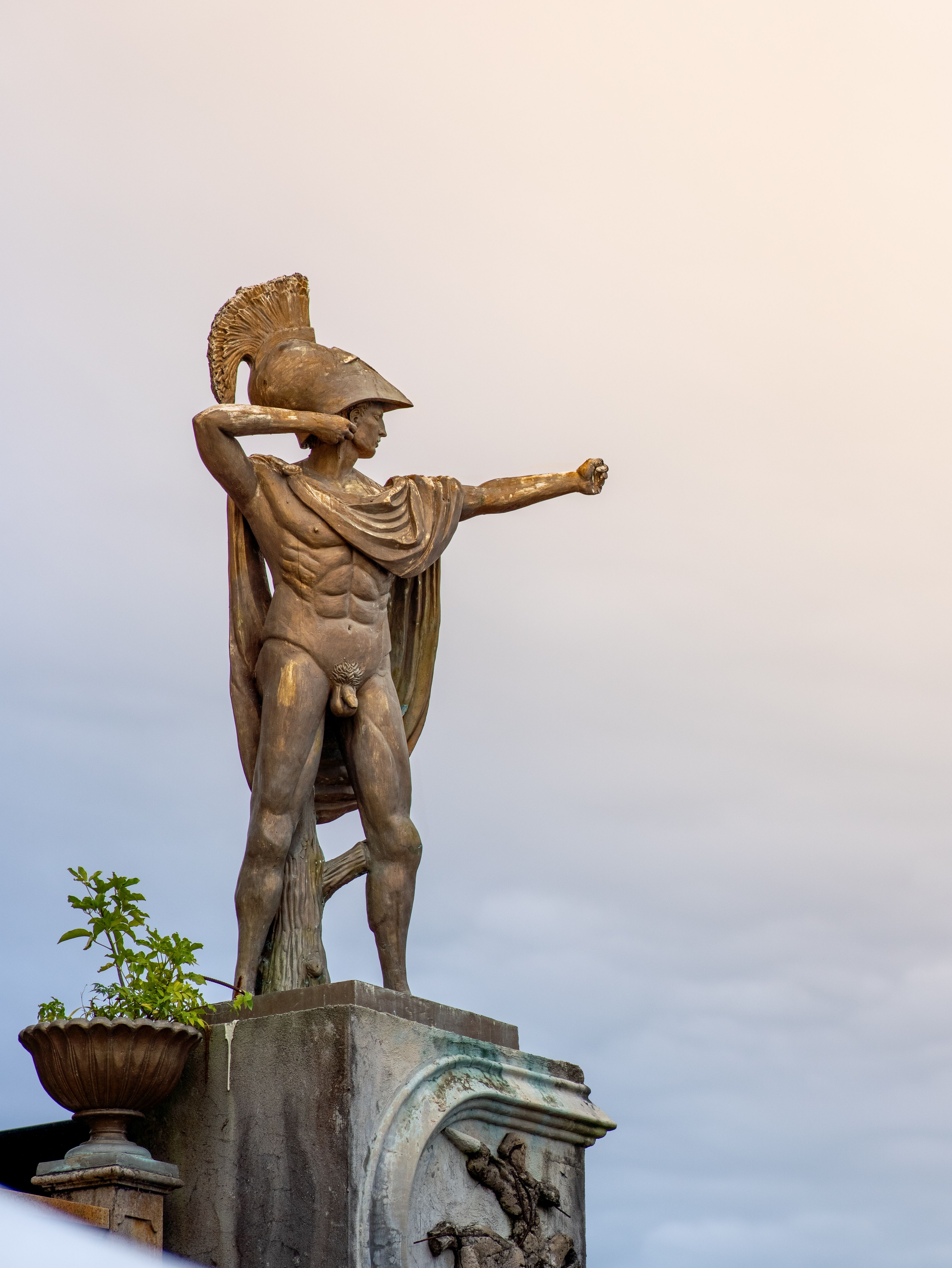 Dramatic statue of an ancient warrior in Cebu City, Philippines, captured at dusk with a striking sky.