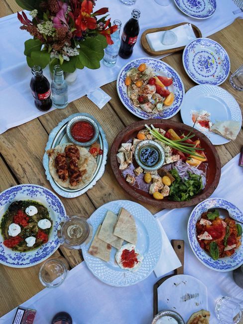A vibrant spread of Mediterranean dishes on a rustic wooden table, perfect for outdoor dining.