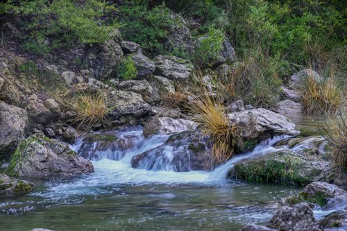 Free Picturesque stream flowing through rocks and greenery in Cazorla, Andalucía, capturing nature's tranquility. Stock Photo