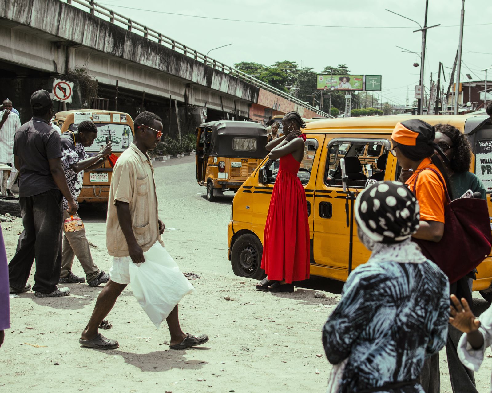 A lively Lagos neighbourhood street with neighbours and a yellow danfo