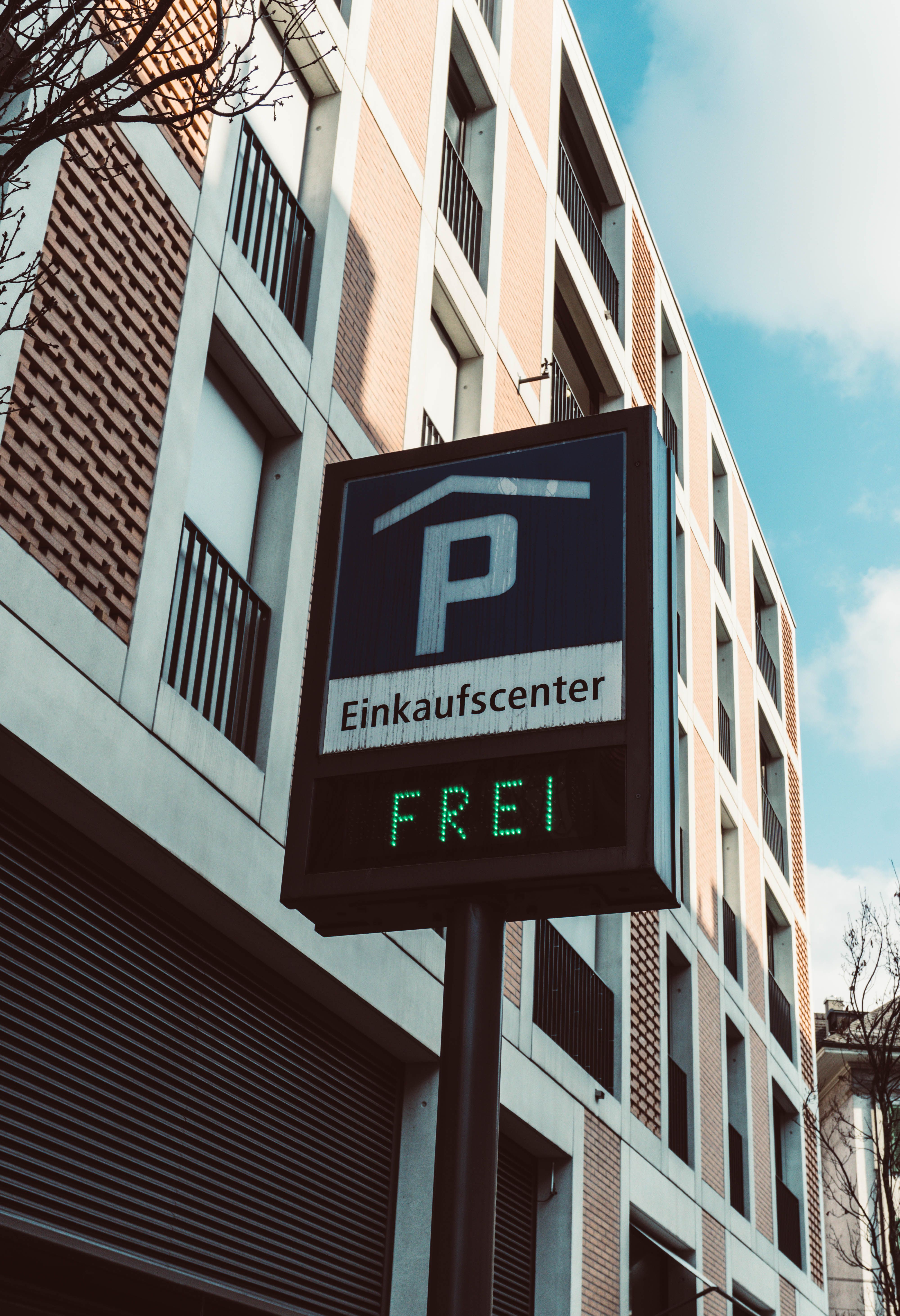 Parking availability sign outside a modern shopping center in Berne, Switzerland.