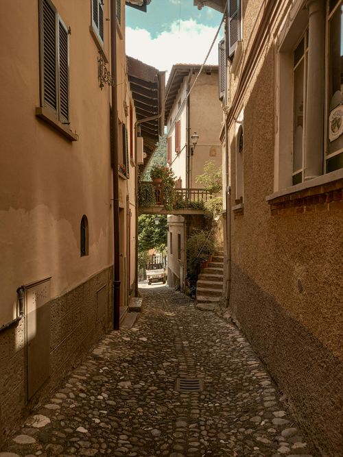 Free Explore a quaint European alleyway with charming historic buildings and cobblestone path. Stock Photo