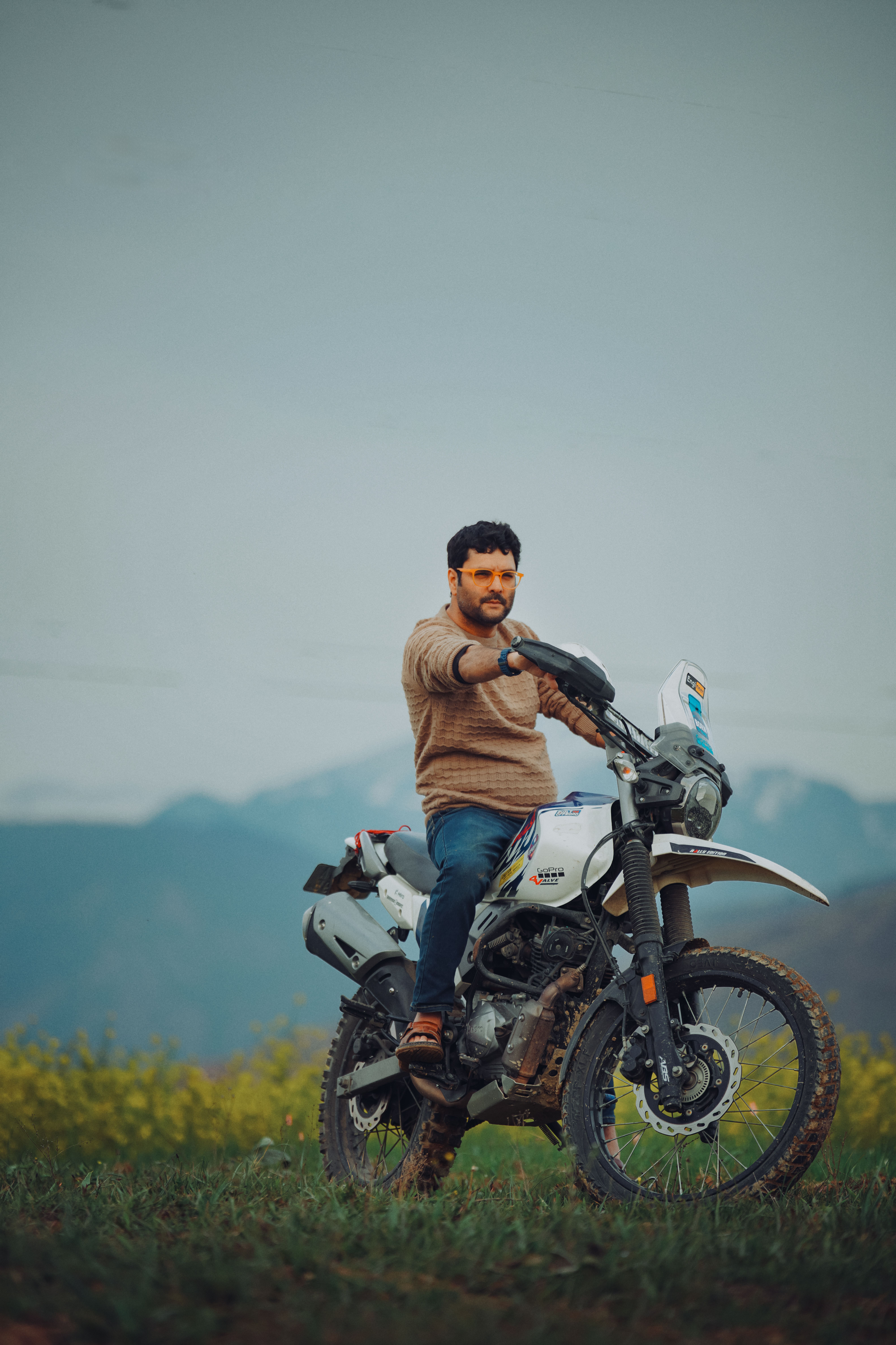 Man on a motorcycle in picturesque Kashmir's mustard fields.