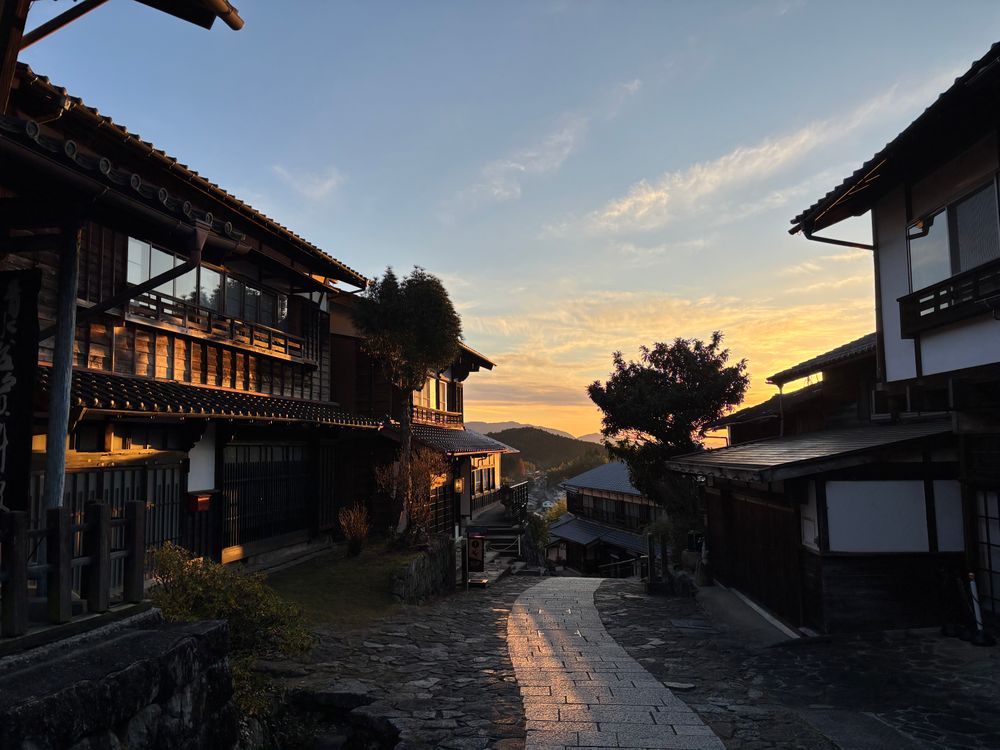 Warm sunset over a stone street and traditional wooden houses in Magome, Japan